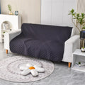 Reversible dog blanket on a sofa showing two colour sides, available in multiple sizes.