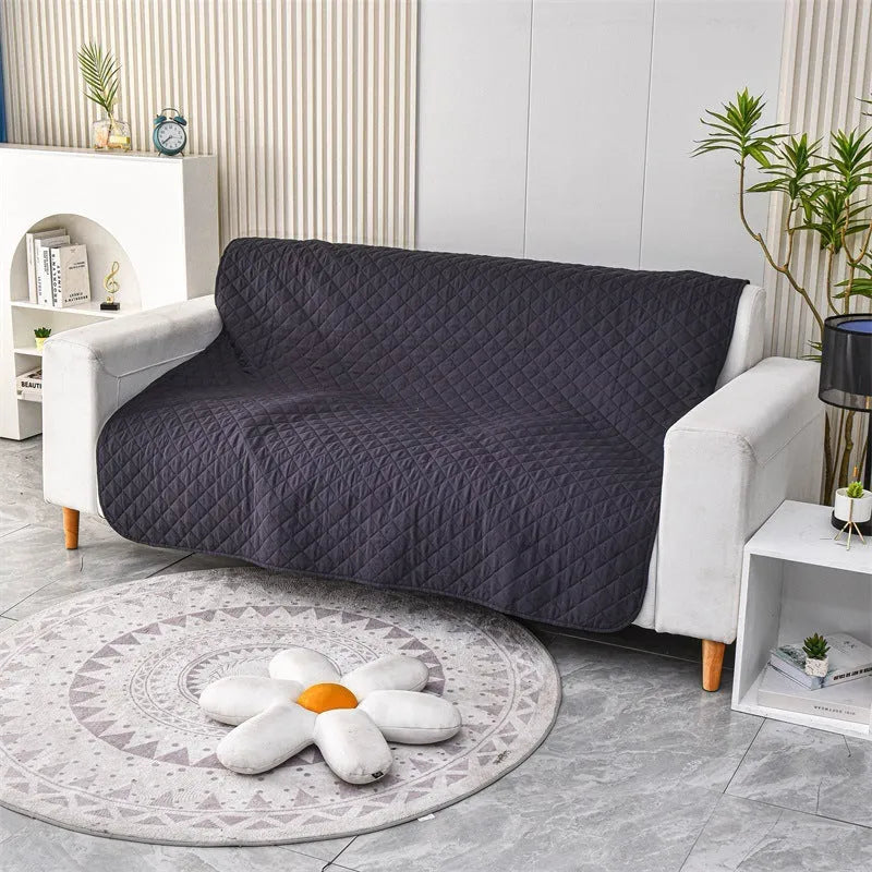 Reversible dog blanket on a sofa showing two colour sides, available in multiple sizes.