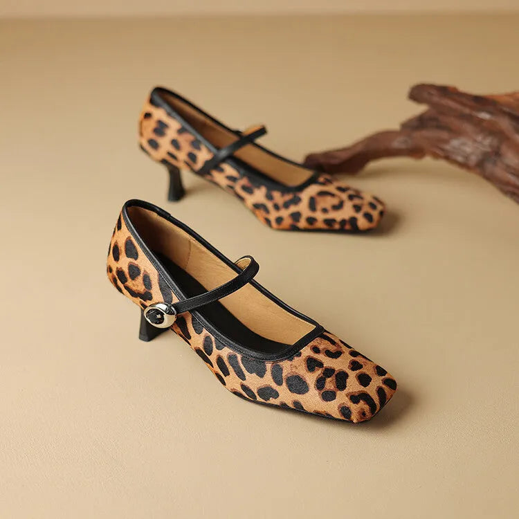 Women's black square toe stiletto heel ankle-strap shoes with horse hair upper on a neutral background.