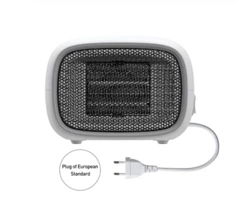Mini green desktop heater with metal grille showing compact size on a wooden desk