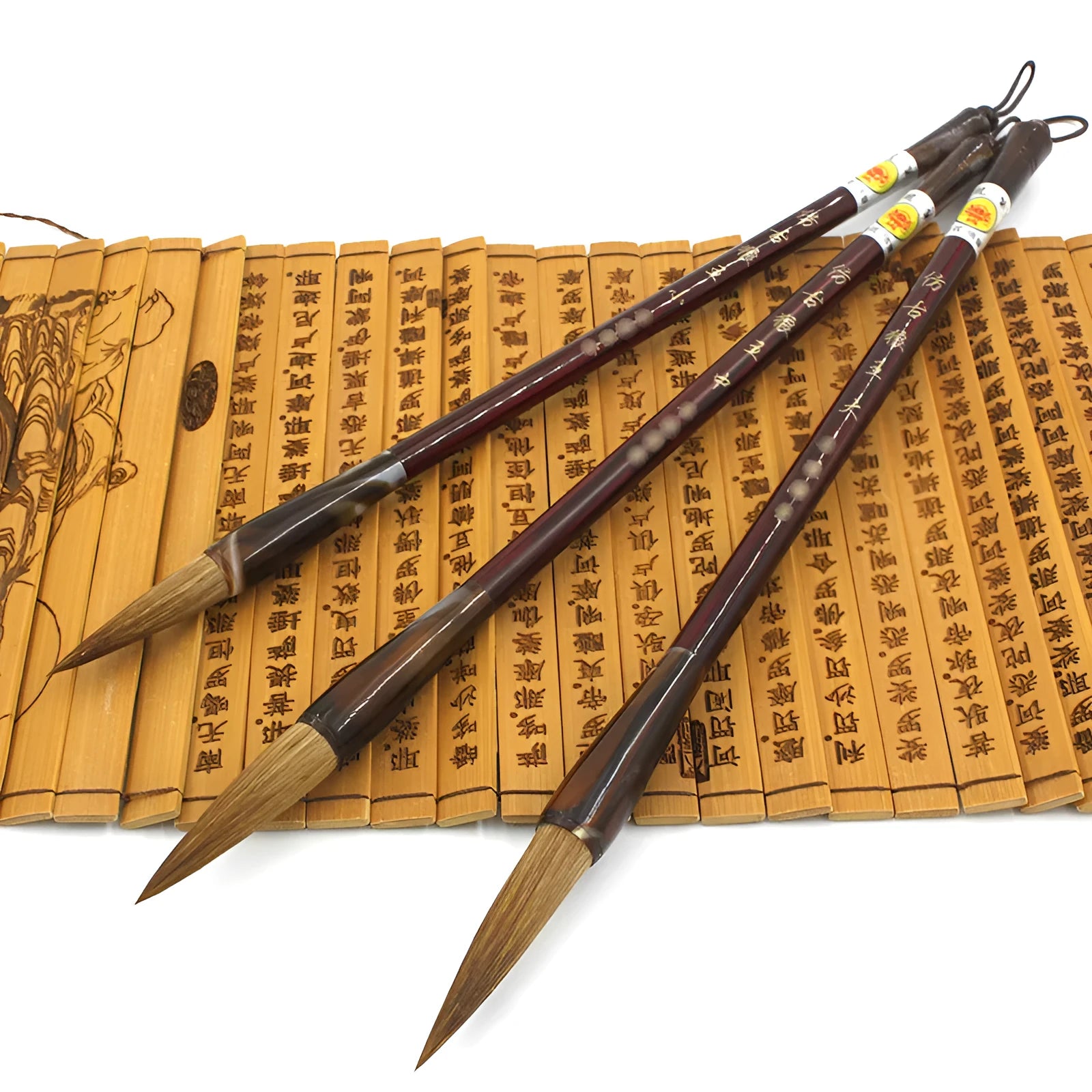 Set of three traditional Chinese calligraphy brushes with wolf hair bristles and steel ferrules in large, medium, and small sizes.