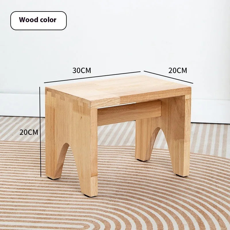 Solid wood shoe changing stool with distressed finish and bracket structure in a living room setting