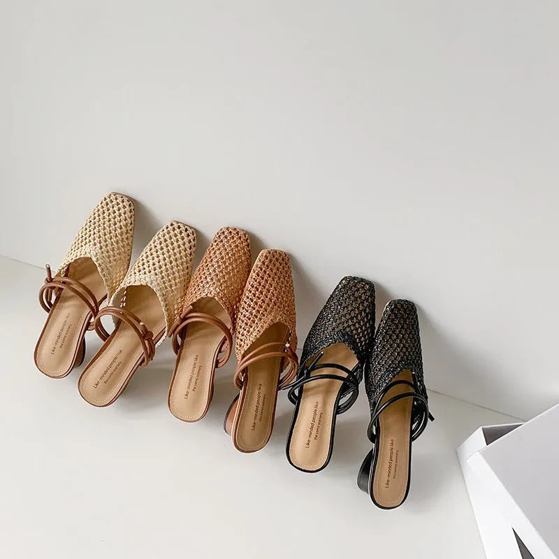 Women's black square toe slippers with chunky heel and breathable hollow-out design on a wooden floor