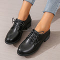 Black women's low-top work shoes with a thick chunky rubber heel and a PU leather upper