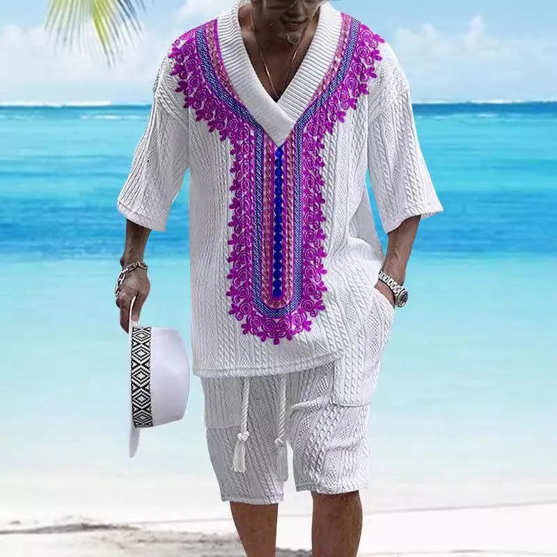 Man wearing a printed drop-shoulder short-sleeved knitted top with matching shorts in a blue colour.