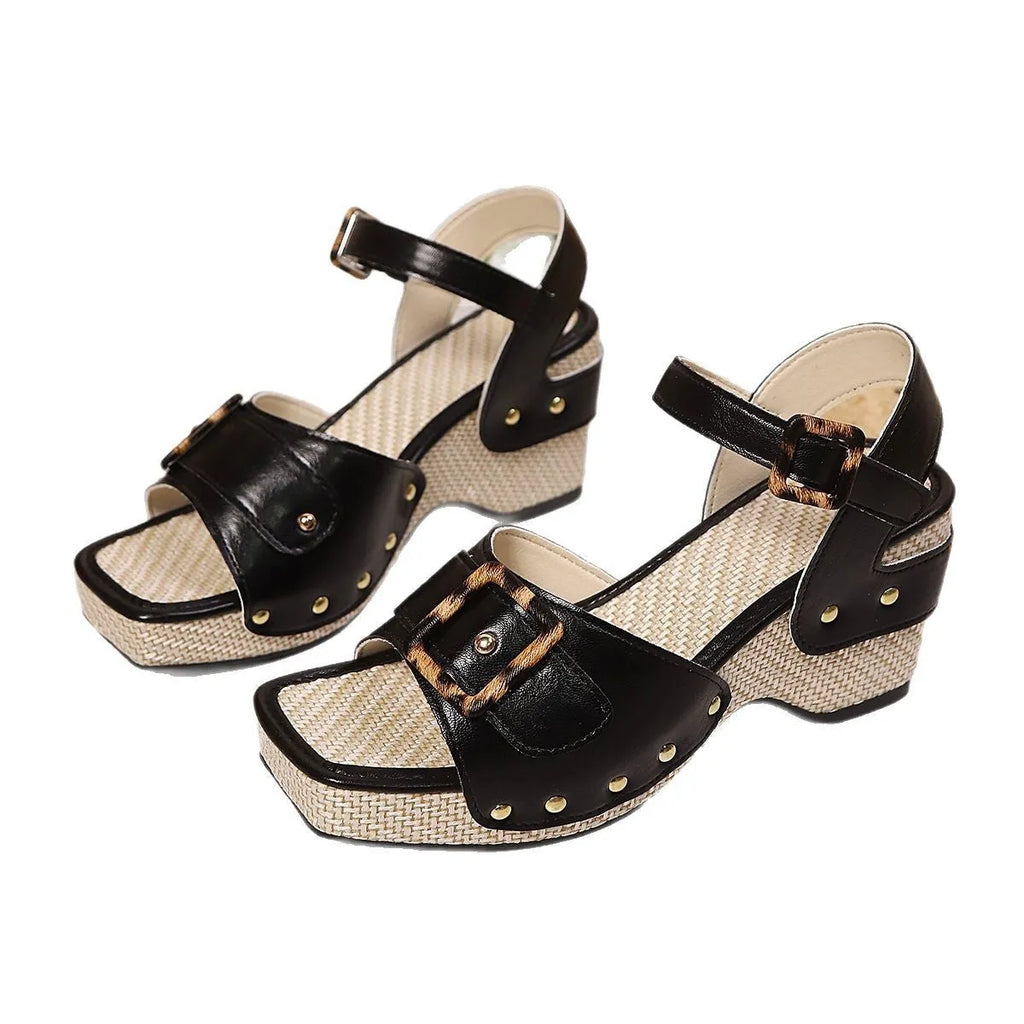 Women's black chunky heel sandals with a square toe and metal button buckle closure on a rubber sole.