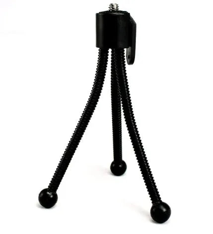 Small black iron frame mini tripod with ball head, shown folded and extended next to a smartphone.
