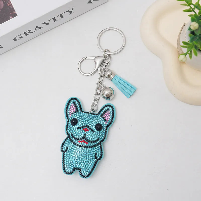 Close-up of a French dog-themed rhinestone keychain pendant with a cartoon bear design, in caramel colour.