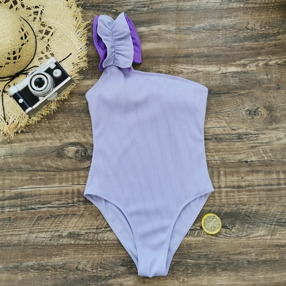 Women's solid colour single-shoulder suspender tube top one-piece swimsuit on a mannequin.