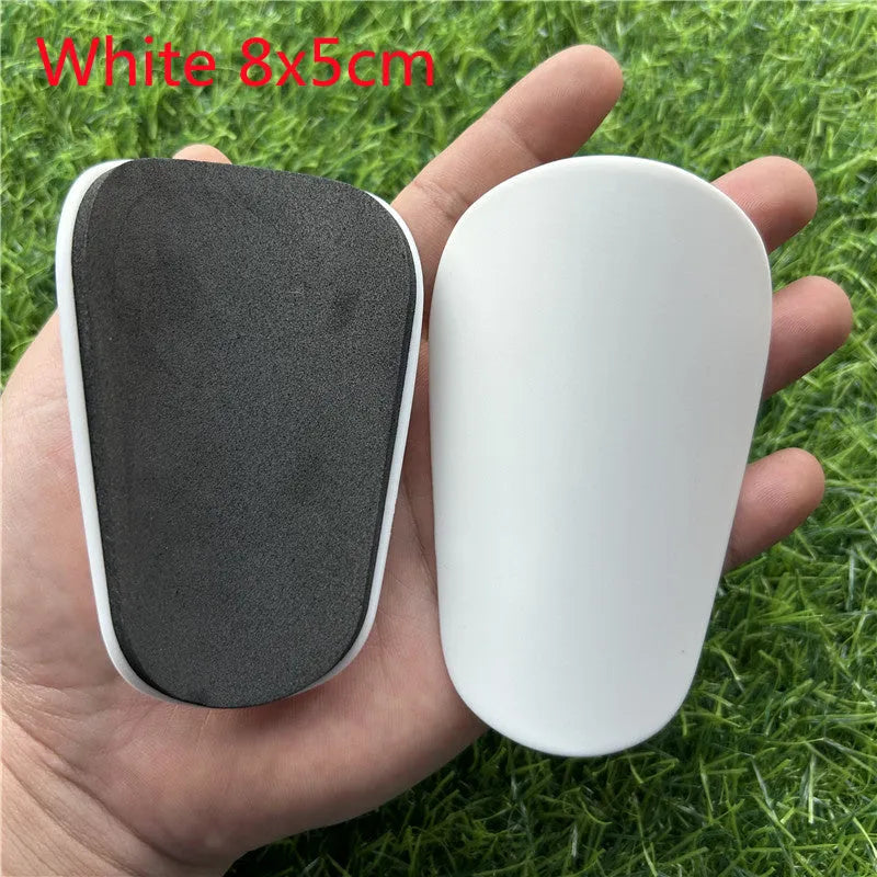 Extra small plastic football shin guards measuring 8x5cm in black and white for youth players