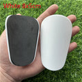 Extra small plastic football shin guards measuring 8x5cm in black and white for youth players