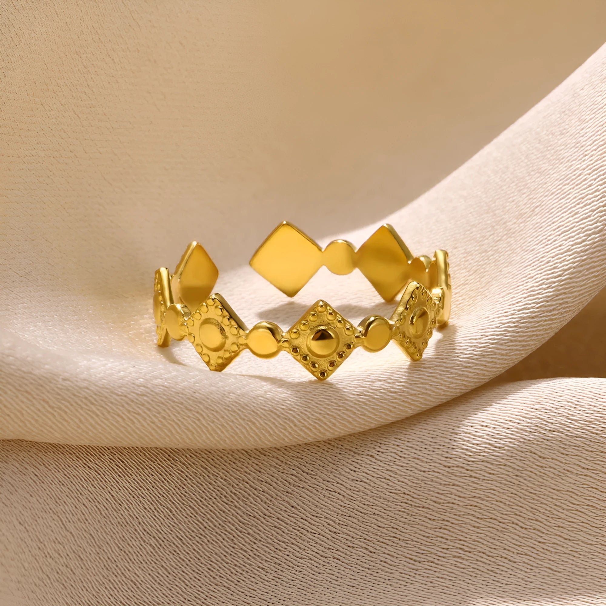Geometric gold titanium steel ring on a neutral background.