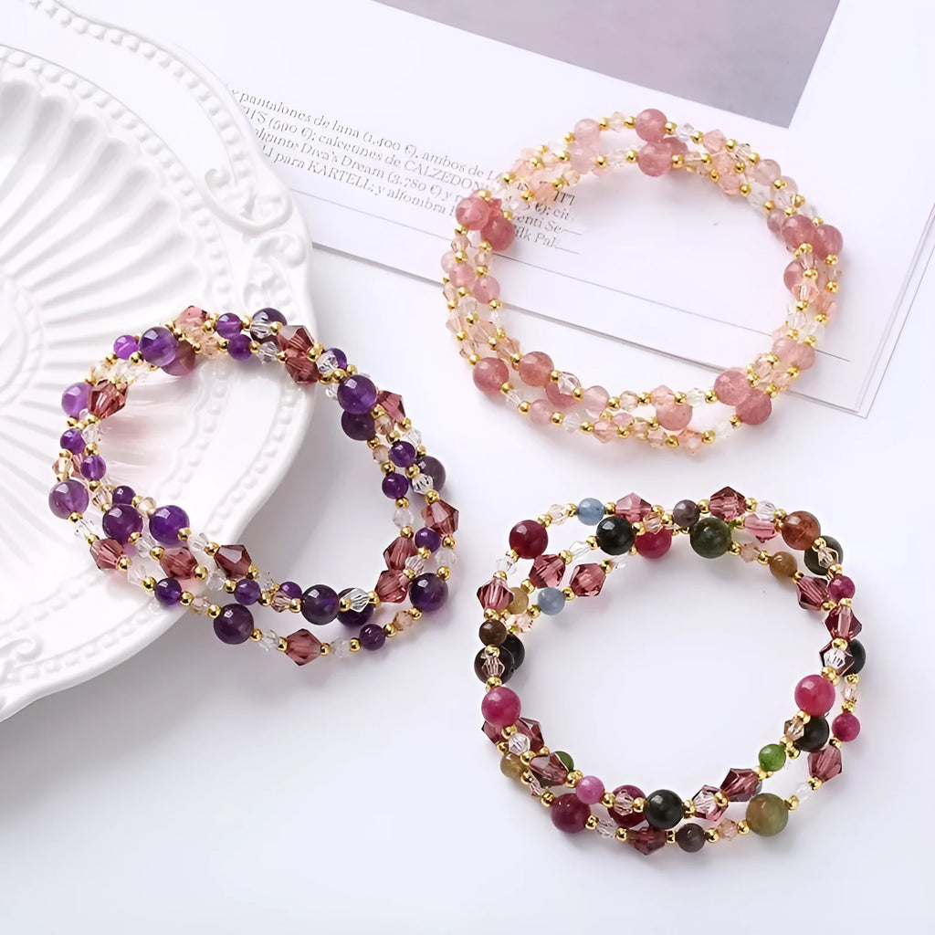 Handmade adjustable bracelet with three crystal rings: tourmaline, strawberry quartz, and amethyst.
