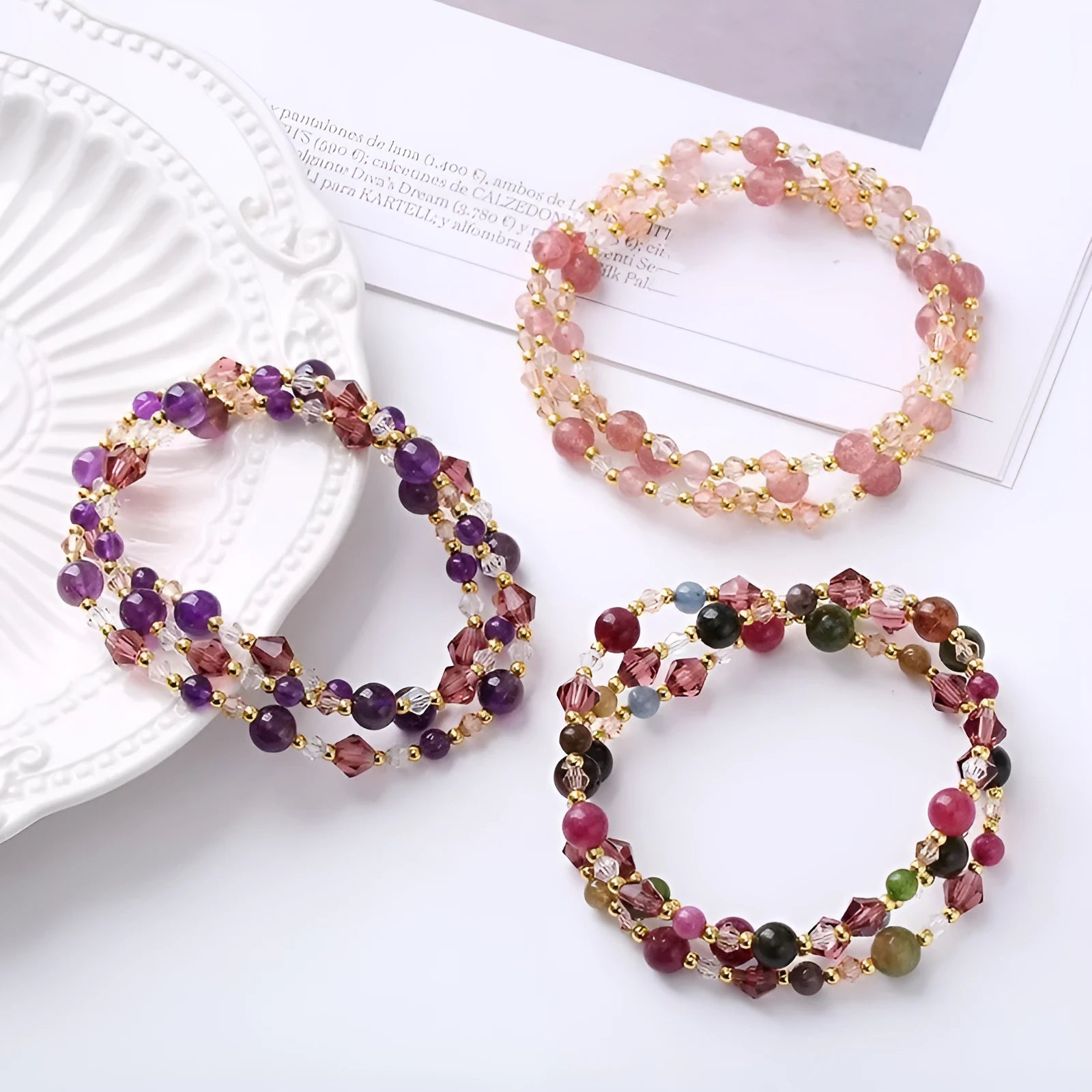 Handmade adjustable bracelet with three crystal rings: tourmaline, strawberry quartz, and amethyst.