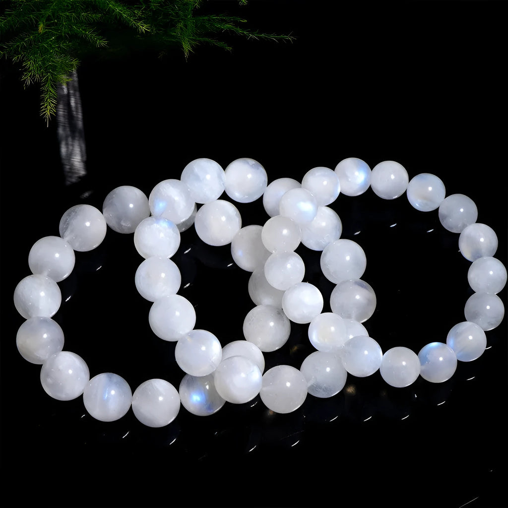 Natural blue moonlight round bead bracelet made from polished moonstone stones on a wrist.