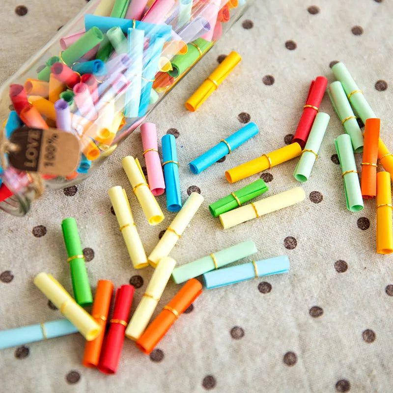 Colourful assortment of small rolled paper scrolls with central holes for drift bottle messages