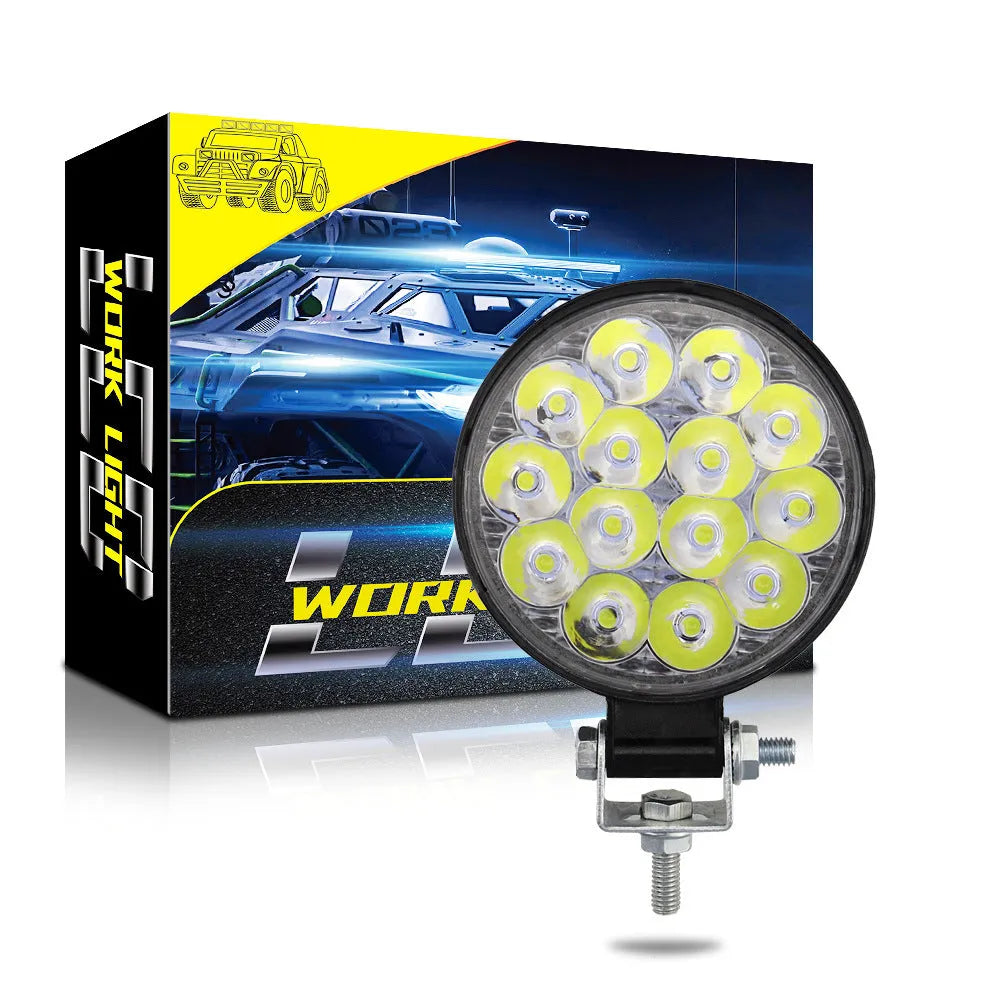 Compact round white LED work light with aluminium housing, suitable for mounting on a vehicle.