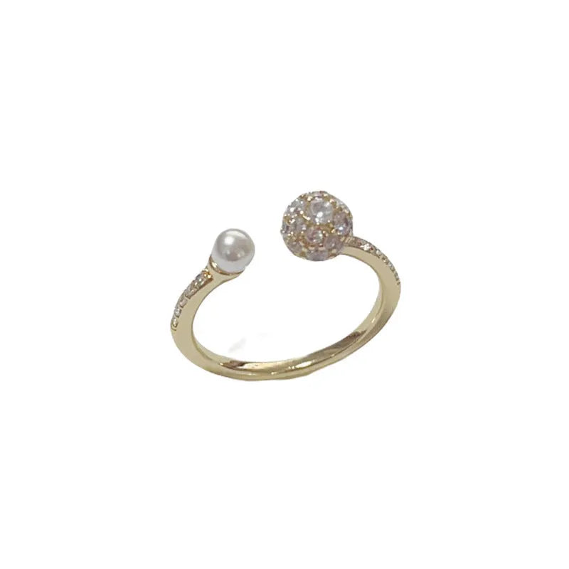 Open-end pearl ring with round zircon stones in gold plating on geometric copper base