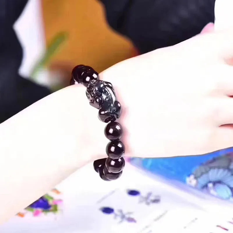 Natural ice colour obsidian crystal bracelet with spherical beads on a wrist.