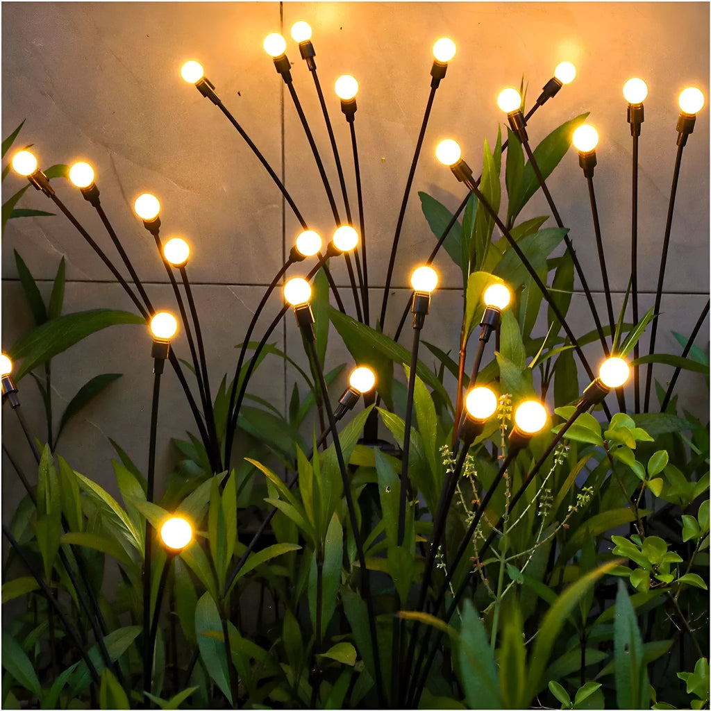 Solar-powered LED ground spike garden light with automatic sensor in lawn