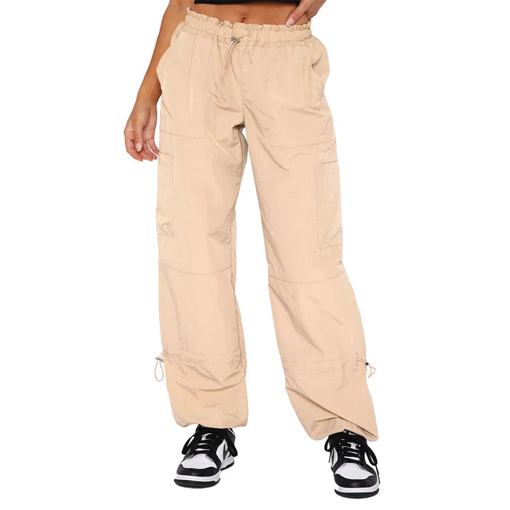 Man wearing beige multi-pocket cargo trousers with a loose straight-leg fit, showcasing the utility pockets.
