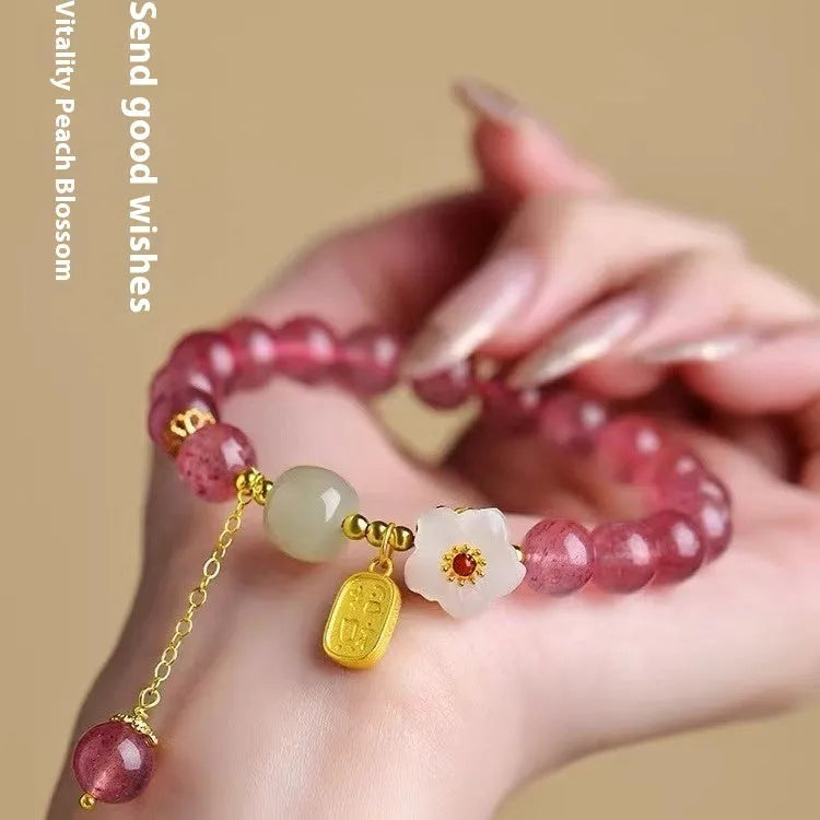 Handcrafted strawberry quartz and Hetian jade bracelet with peach blossom charm for girls.