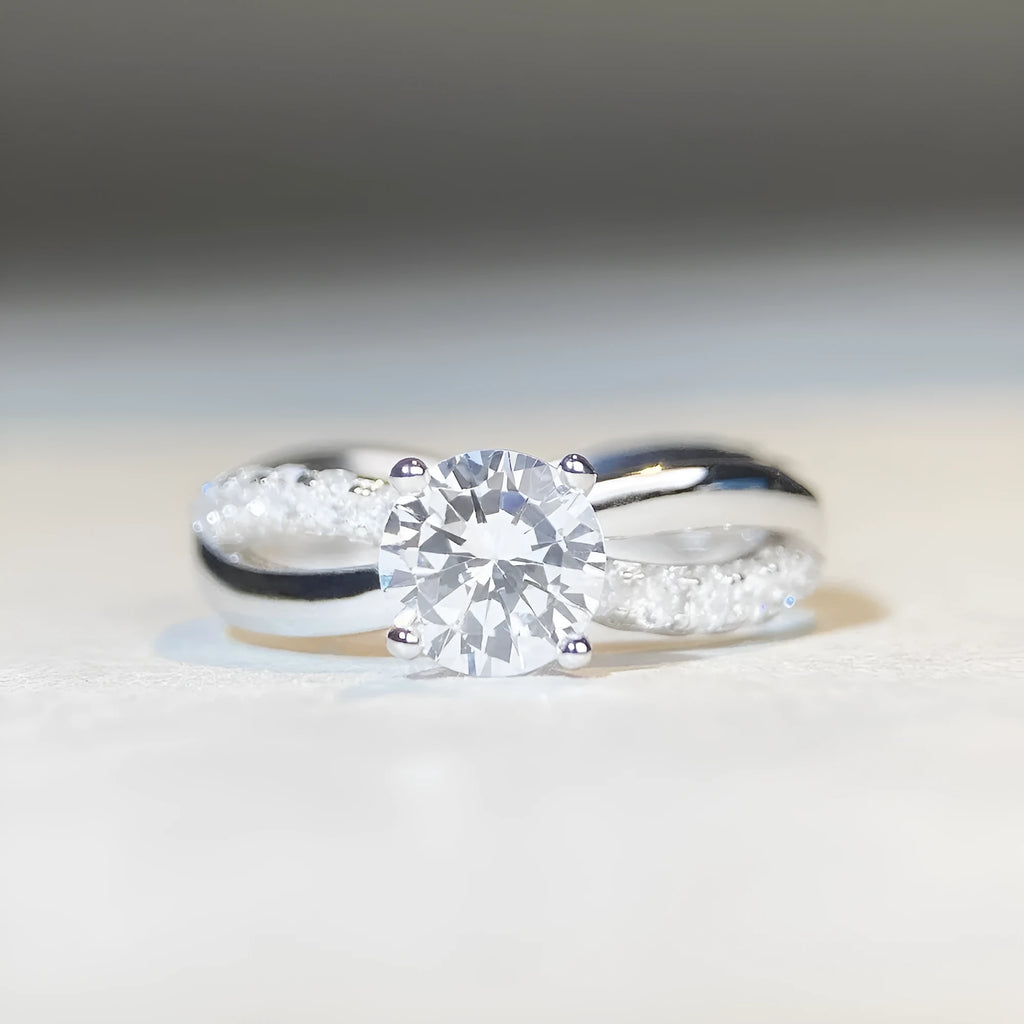 Silver geometric cross ring with a 1 karat moissanite stone and twisted band.