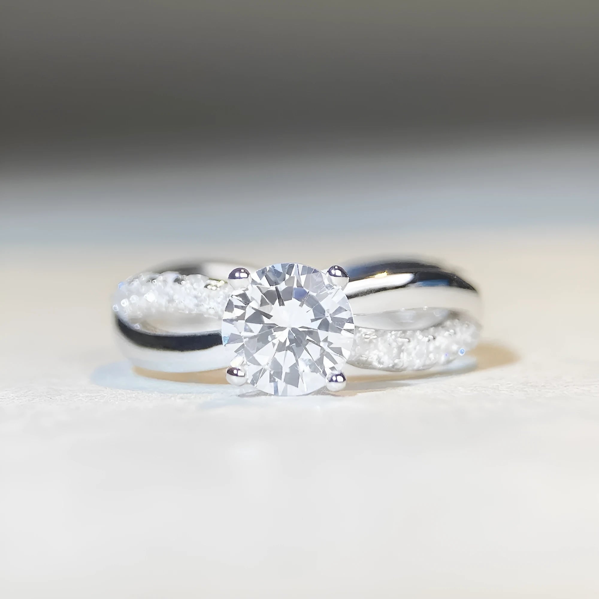 Silver geometric cross ring with a 1 karat moissanite stone and twisted band.
