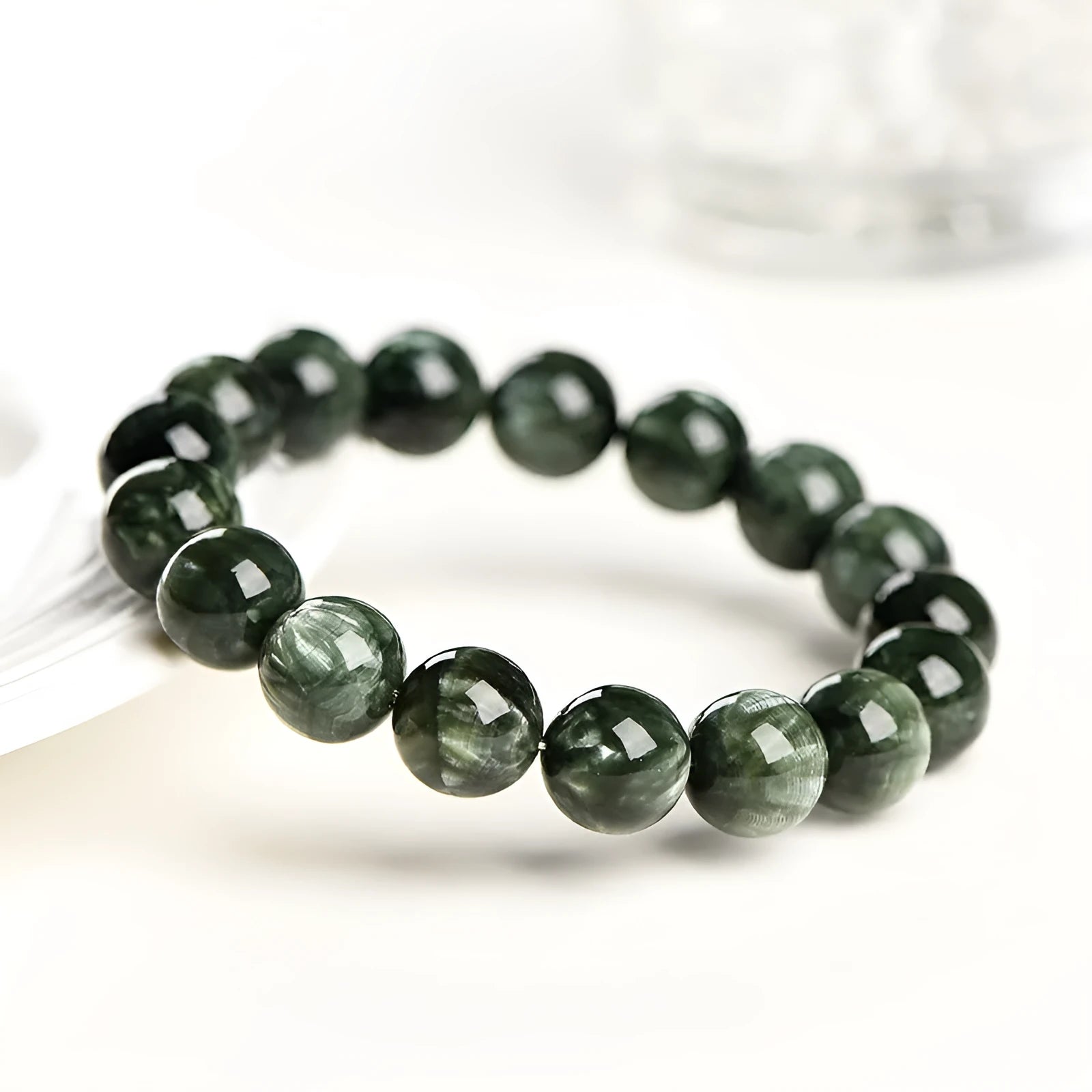 Natural green dragon crystal bracelet with 8-9mm round beads and Ruyi design on wrist.