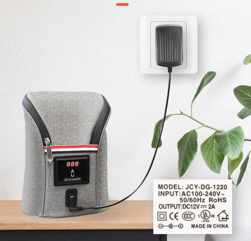 Grey portable car baby bottle warmer with dual slots and digital temperature display screen connected to 12V charger