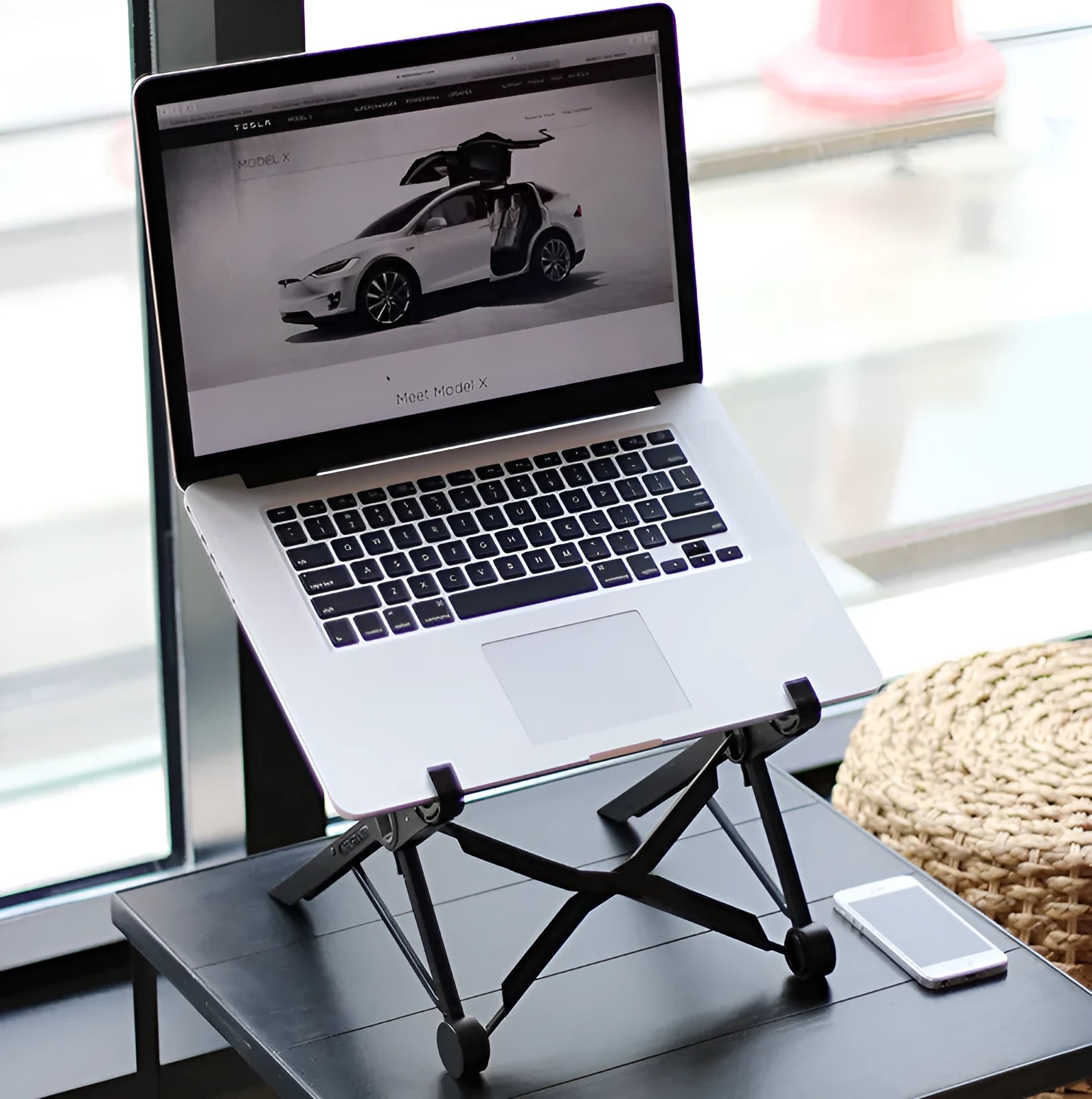 Black folding laptop stand with adjustable height mechanism and reinforced nylon construction