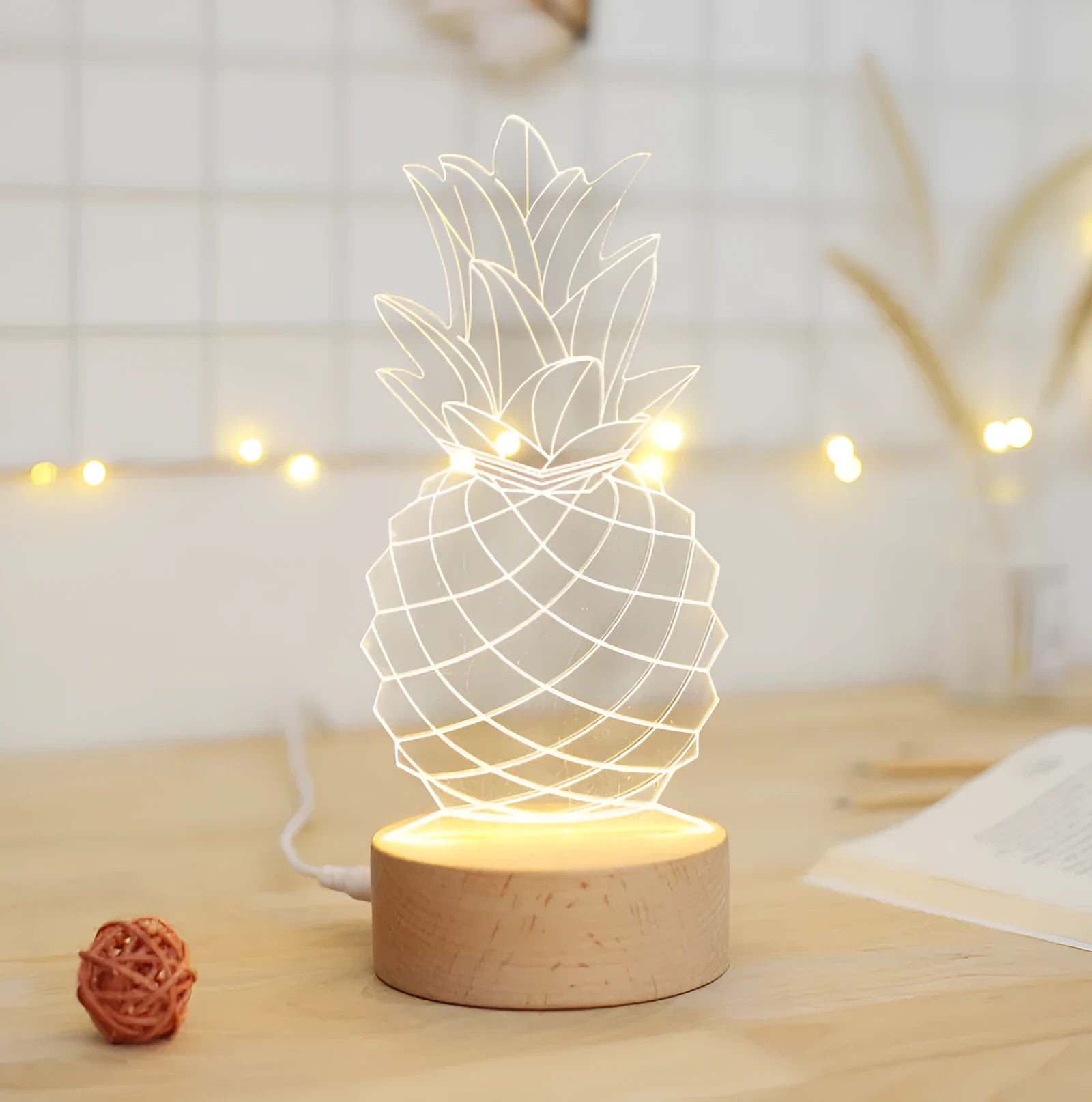 Wood and acrylic pineapple-shaped USB table lamp with dimmer switch on a bedside table.