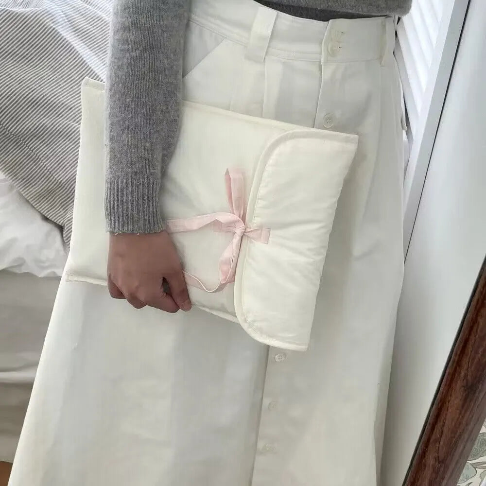 Women's black and white quilted nylon laptop bag with a ballet-style bow.