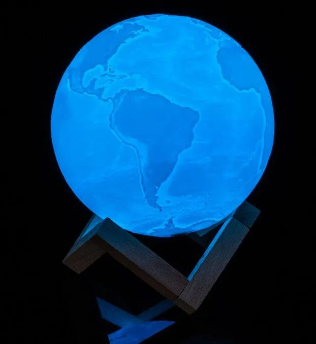 3D printed white moon lamp on a wooden stand, showing detailed craters and soft LED glow.
