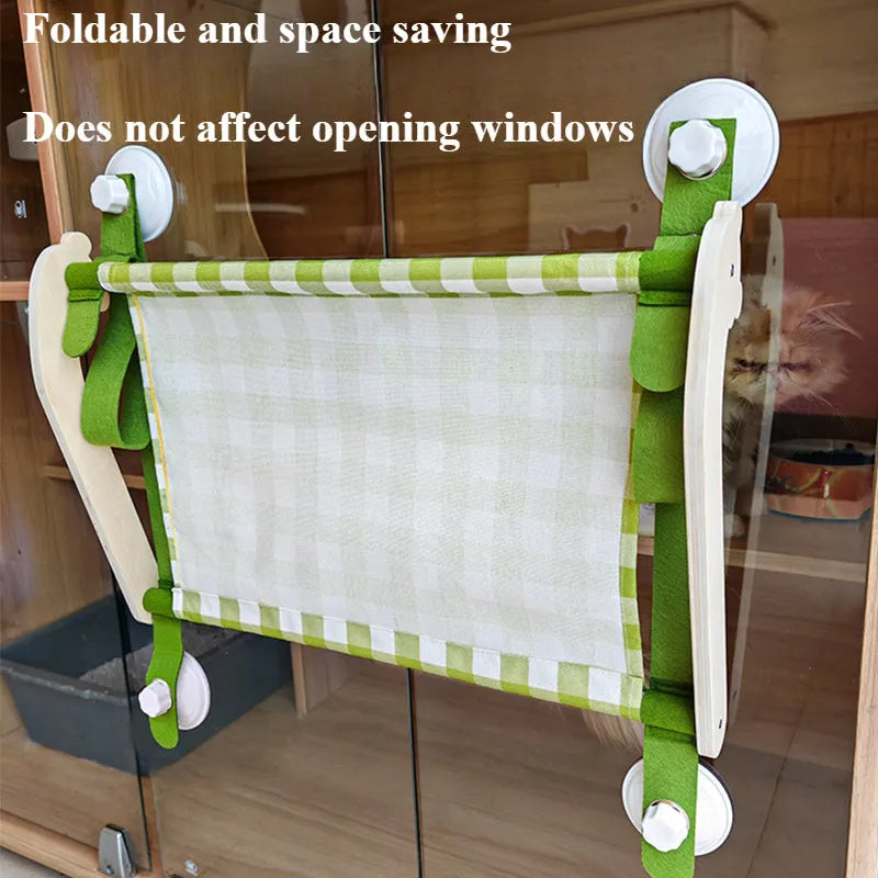 Foldable wooden cat window hammock with suction cups attached to a glass pane.