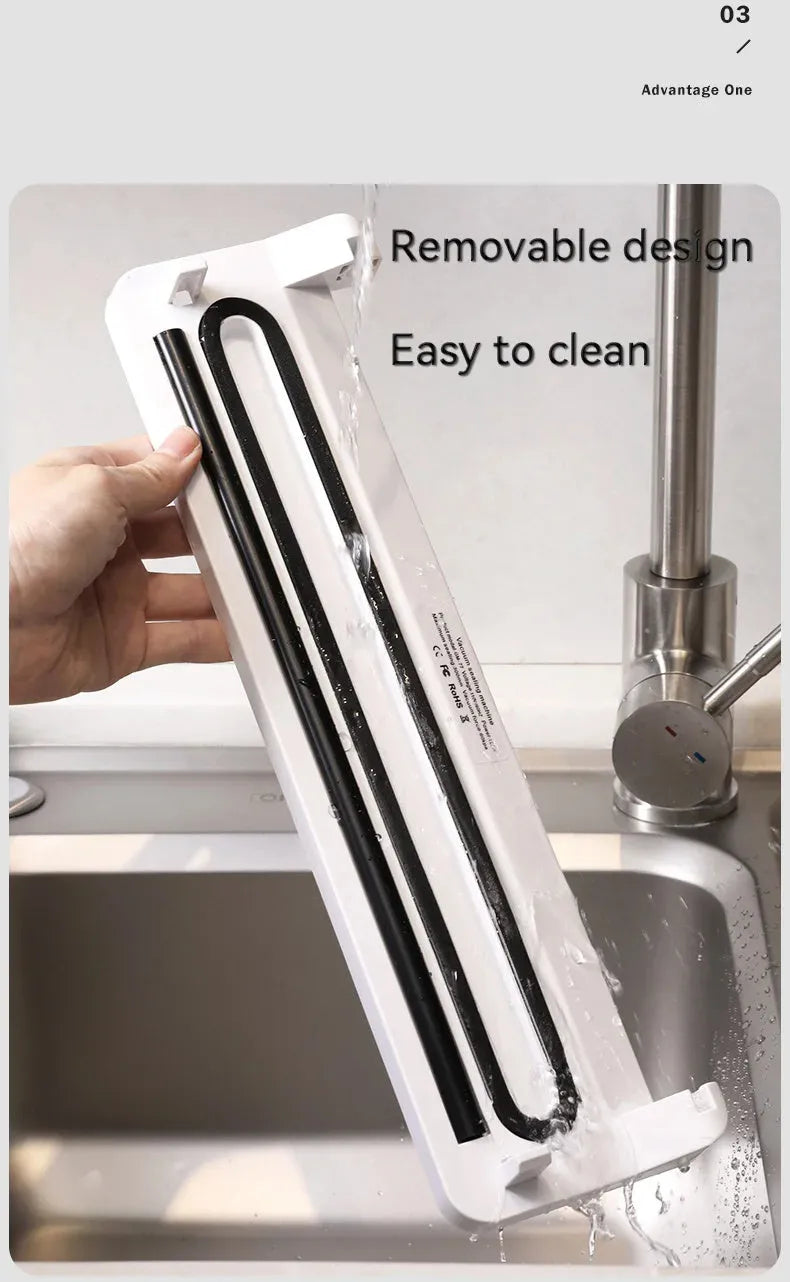 White compact automatic vacuum sealer machine for household food preservation on a kitchen counter.