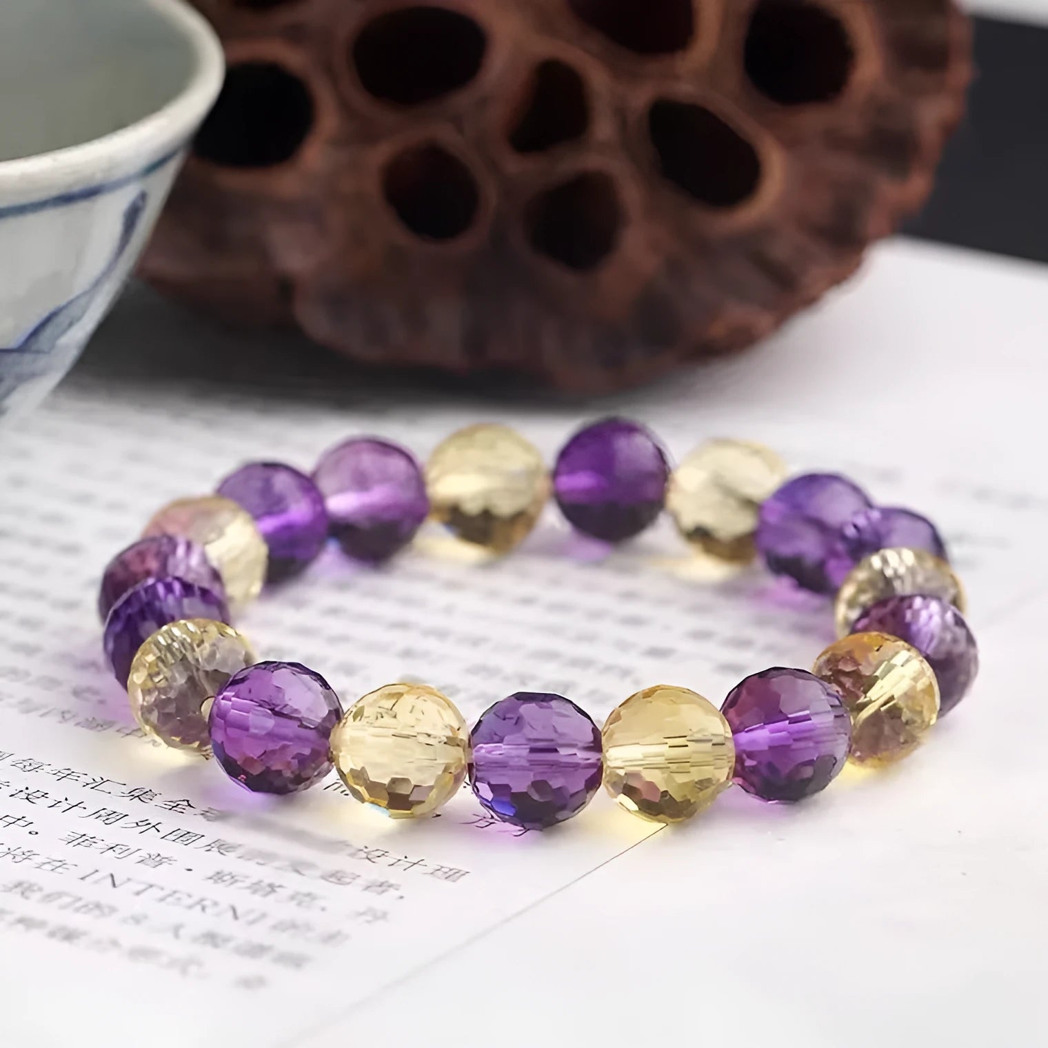 Handcrafted ametrine crystal bracelet with 128-faceted beads and a zodiac charm.