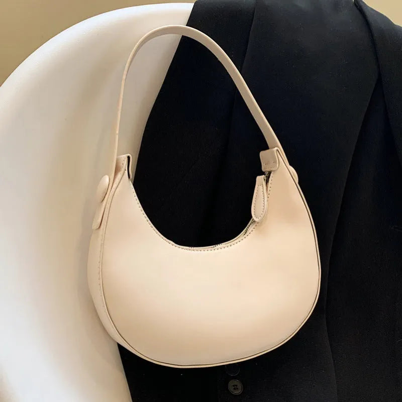 Women's retro PU leather shoulder bag in dumpling shape with zipper pocket, showing cream yellow colour option