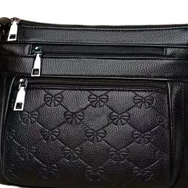 Black women's crossbody messenger bag with embossed texture and shoulder strap