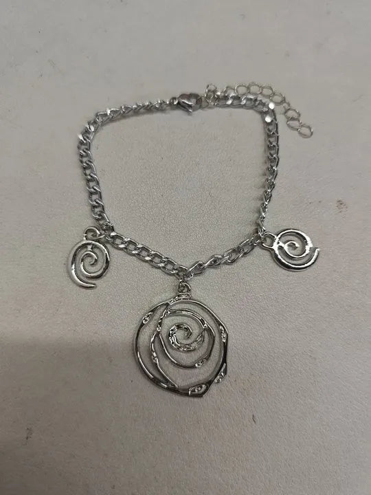 Gold tone spiral donut design necklace, bracelet, and earrings set on a white background.