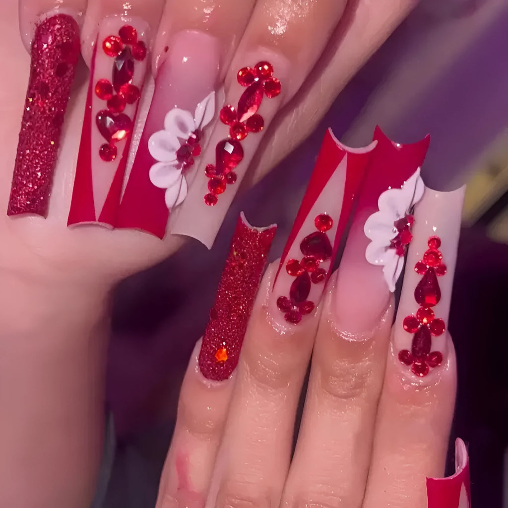 Long coffin shaped press-on false nails with red diamond gemstone and sweet flower pattern decoration.