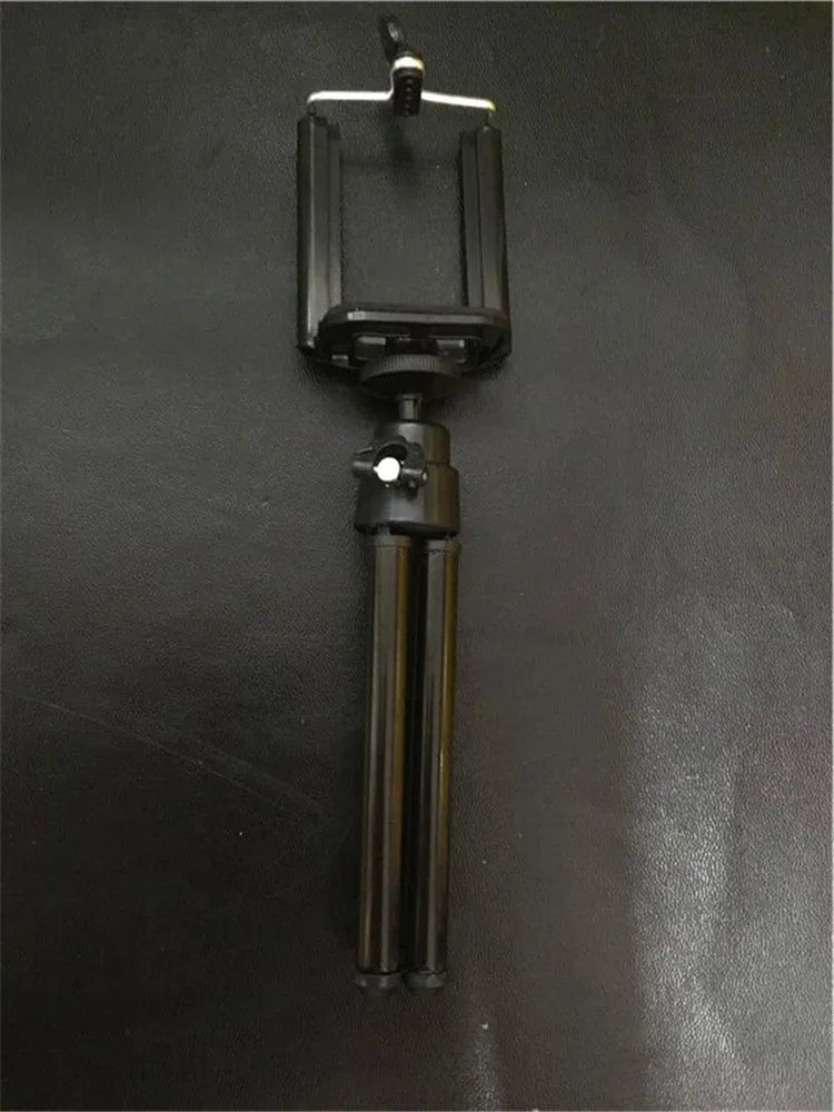 Black adjustable metal desktop phone holder with a two-section bracket holding a smartphone.