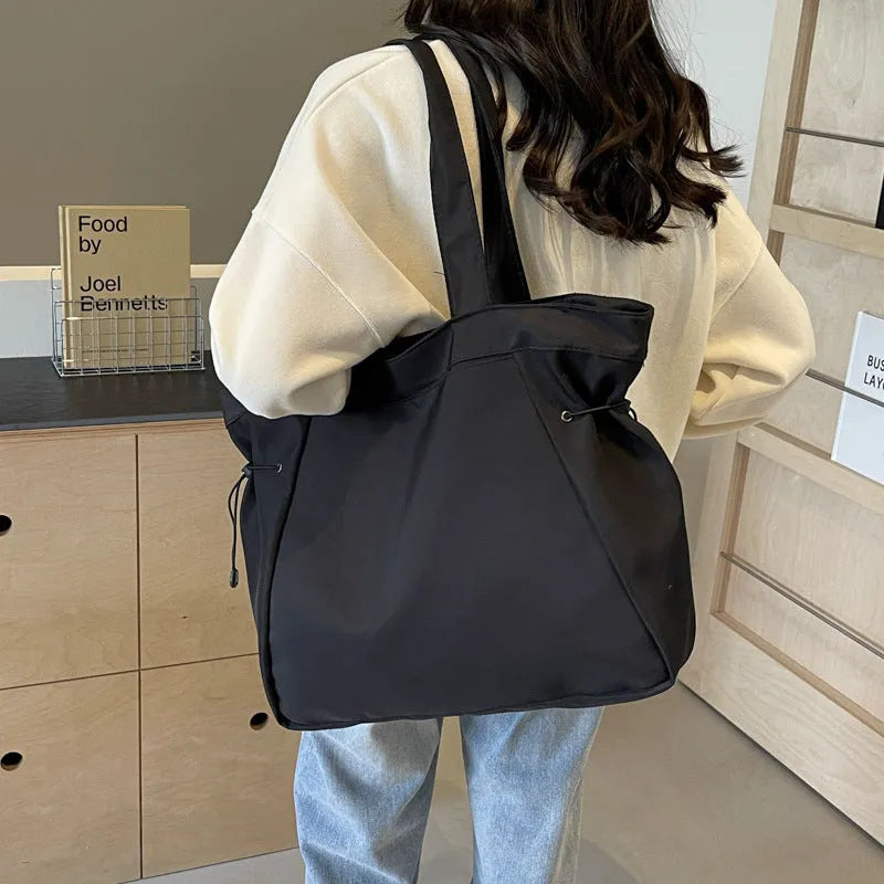 Soft Oxford cloth folding tote bag in a choice of five colours: black, brown, dark grey, light grey, and purple.