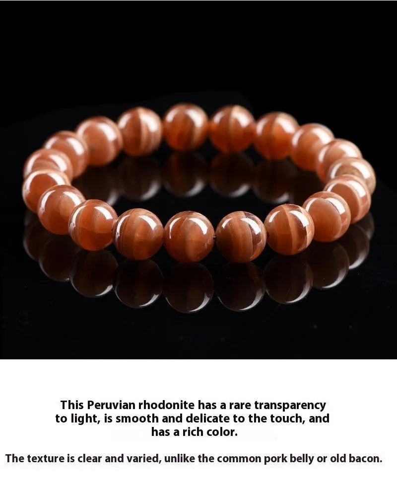 Natural old mine rhodochrosite round bead bracelet with Ruyi symbol on a wrist.