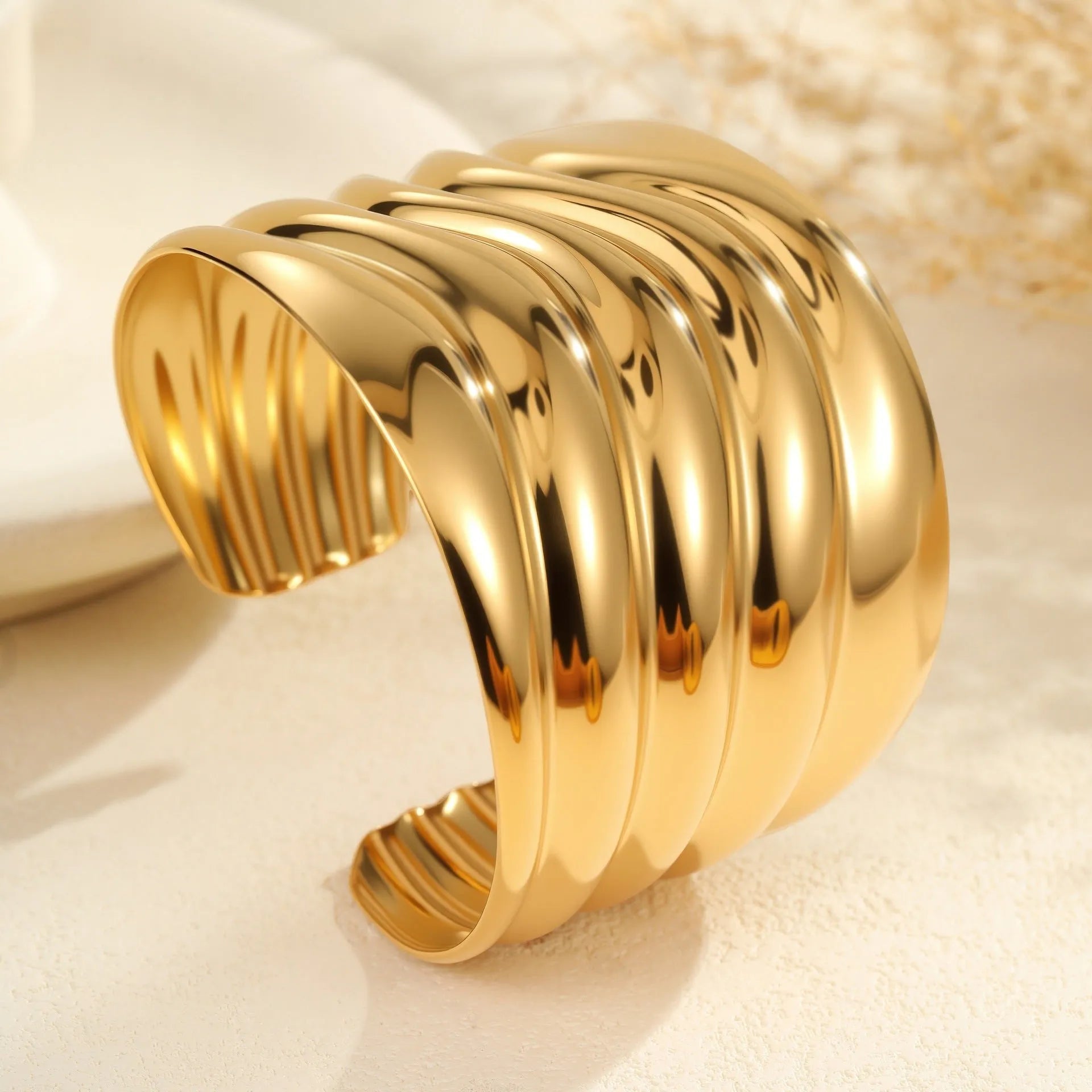 Women's wide stainless steel bracelet with gold plating and wave geometric pattern