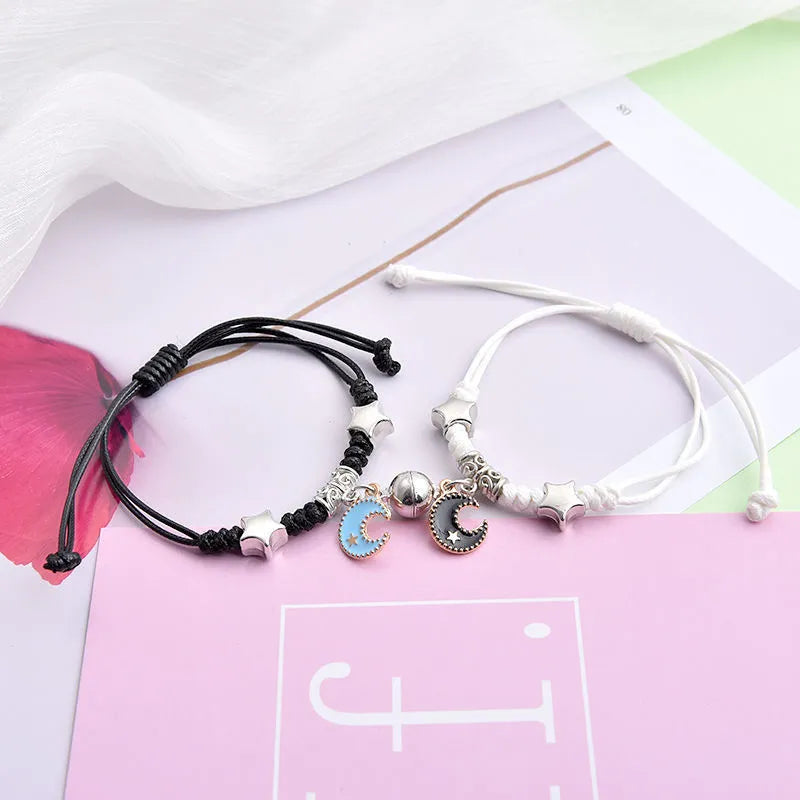 Magnetic couple bracelets with suction clasp showing various charm designs like a crown, clover, and love lock.