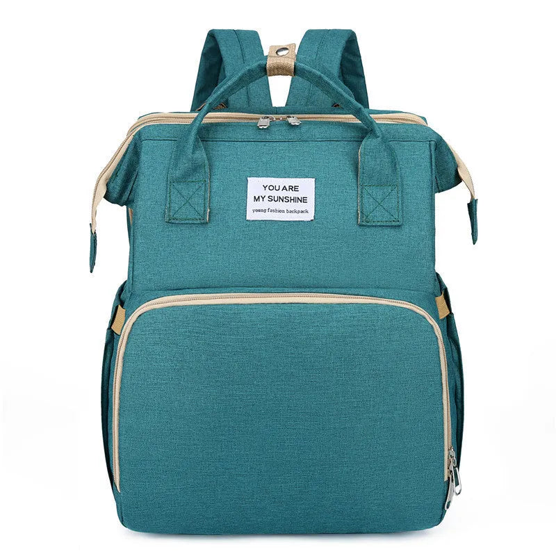Lightweight nylon mother and baby bag with USB port, shown folded and in use with curved shoulder strap.
