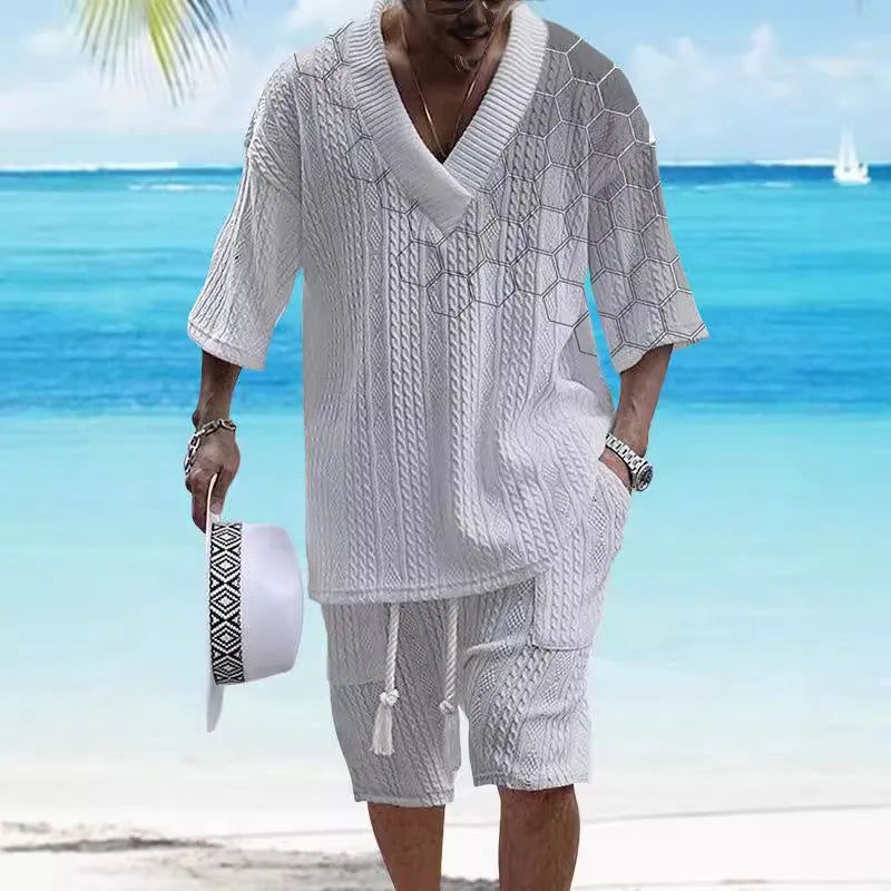 Man wearing a printed drop-shoulder short-sleeved knitted top with matching shorts in a blue colour.