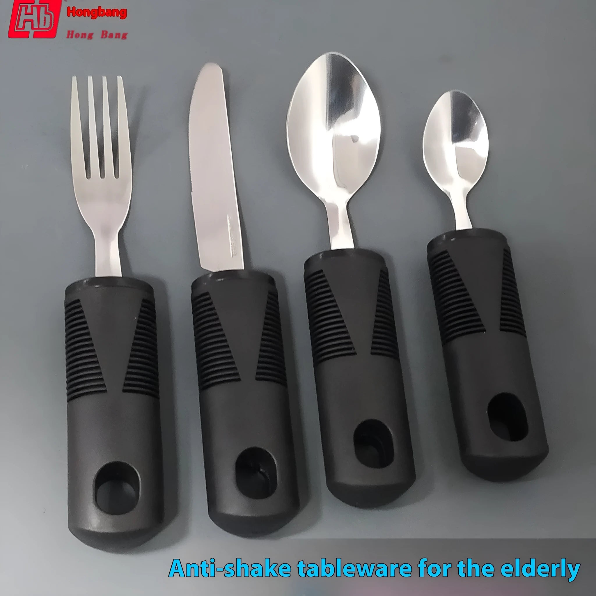 Stainless steel adaptive spoon and spork set with black rubber handle on a table.