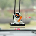 Resin cartoon astronaut car pendant charm in red flag design hanging from a rearview mirror.